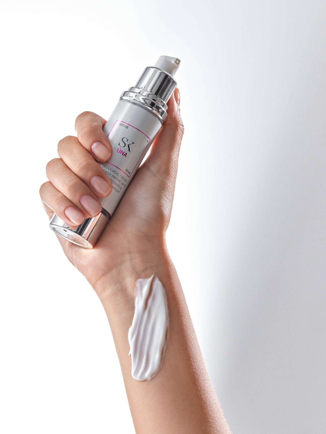 Skintegra Una neutralna krema za suhu, ljuskavu, osjetljivu i atopičnu kožu djece i odraslih u bočici i na ženskoj ruci